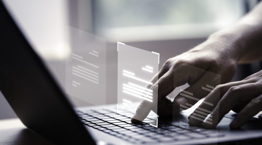 Hand using laptop computer with virtual screen and document for online approve paperless quality assurance and ERP management concept.